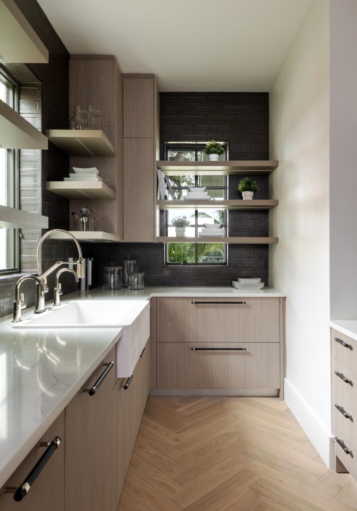 Butler pantry design for modern home with herringbone pattern natural wood floors, custom cabinetry and floating shelves.