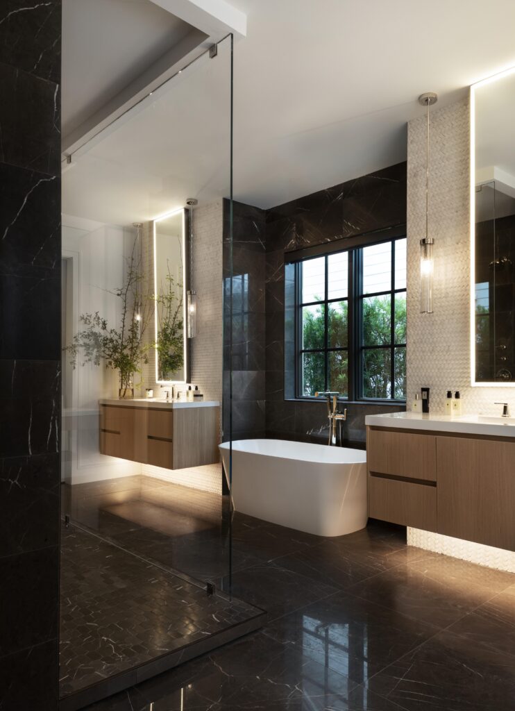 Custom luxury bathroom with soaking tub and dual floating his and hers vanities, with floor-to-ceiling custom tile.