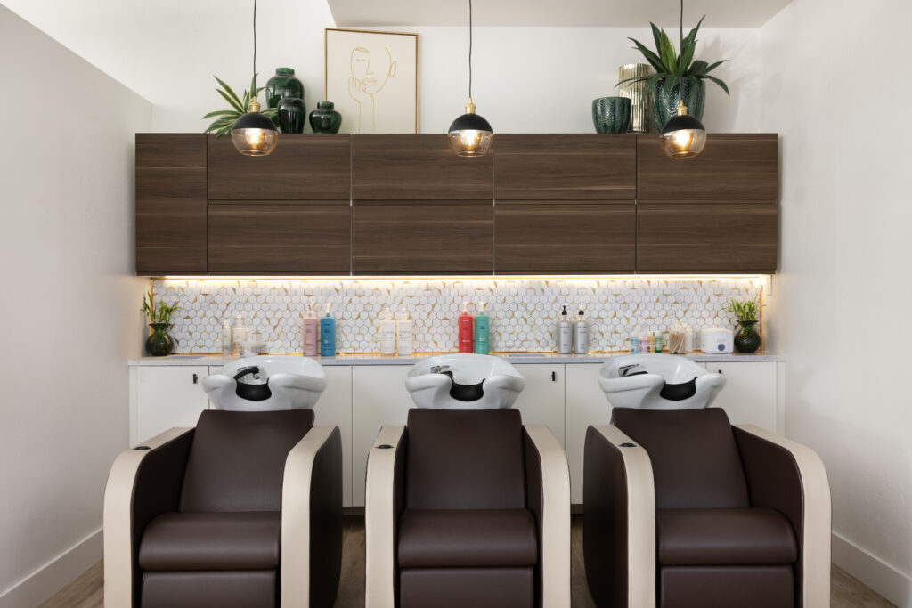 Commercial design of hair washing station in luxury salon based in Naples, Florida. Custom cabinetry, and geometric hexagon tile backsplash.